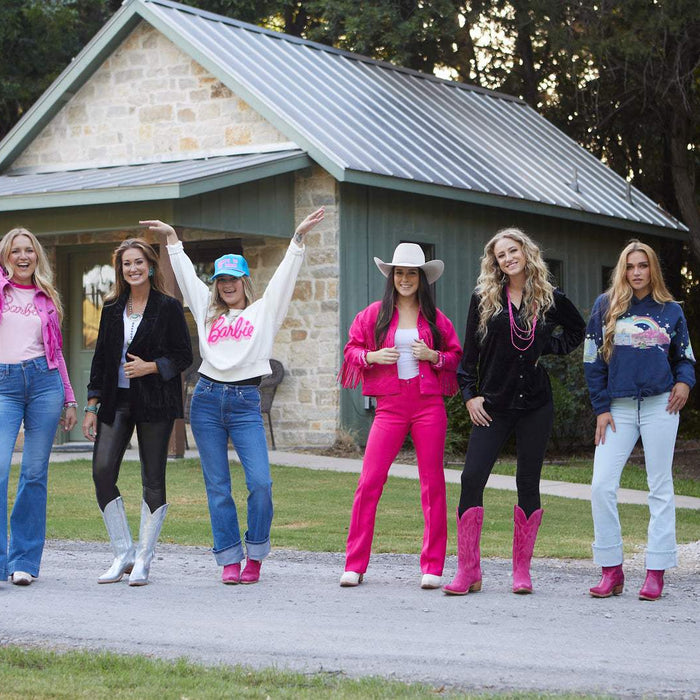 cowgirls wearing pink western wear, pink cowboy boots, and cowboy hats